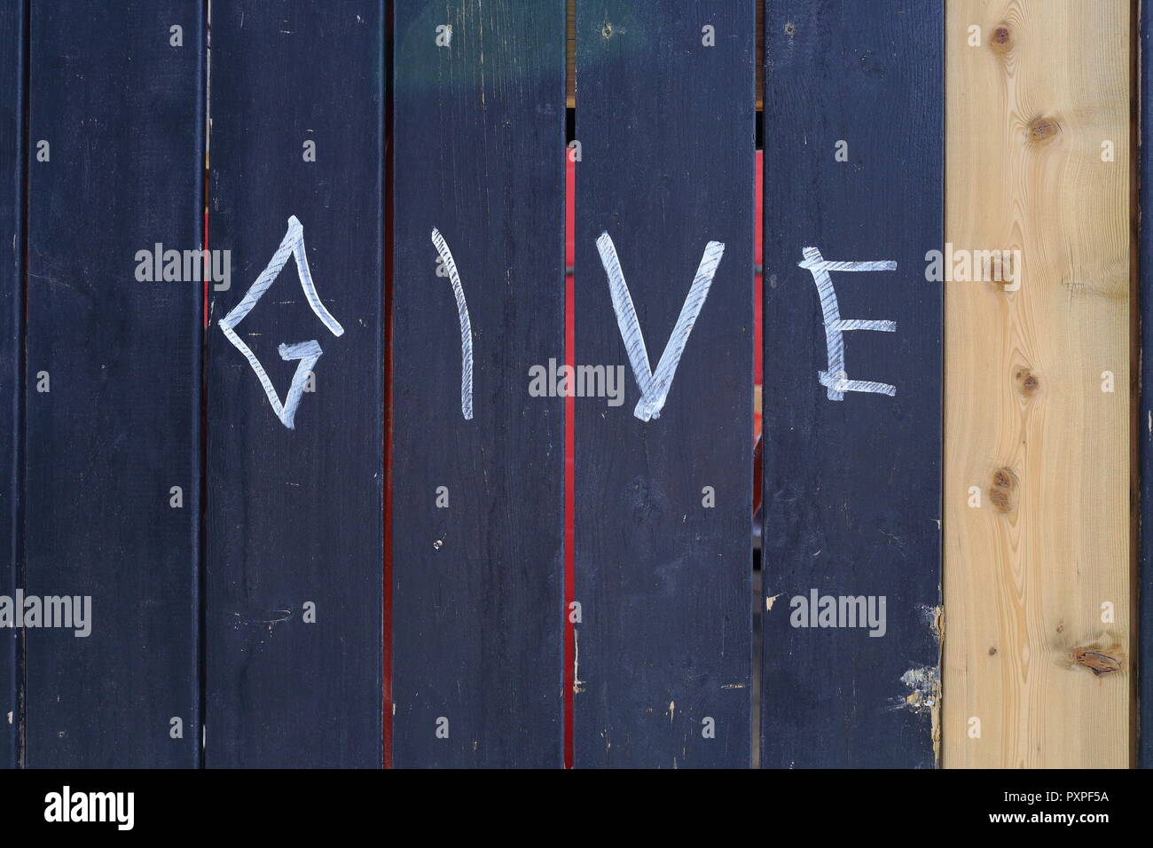 Colpo di blu di recinzione in legno contrassegnati con la parola "dare" Foto Stock
