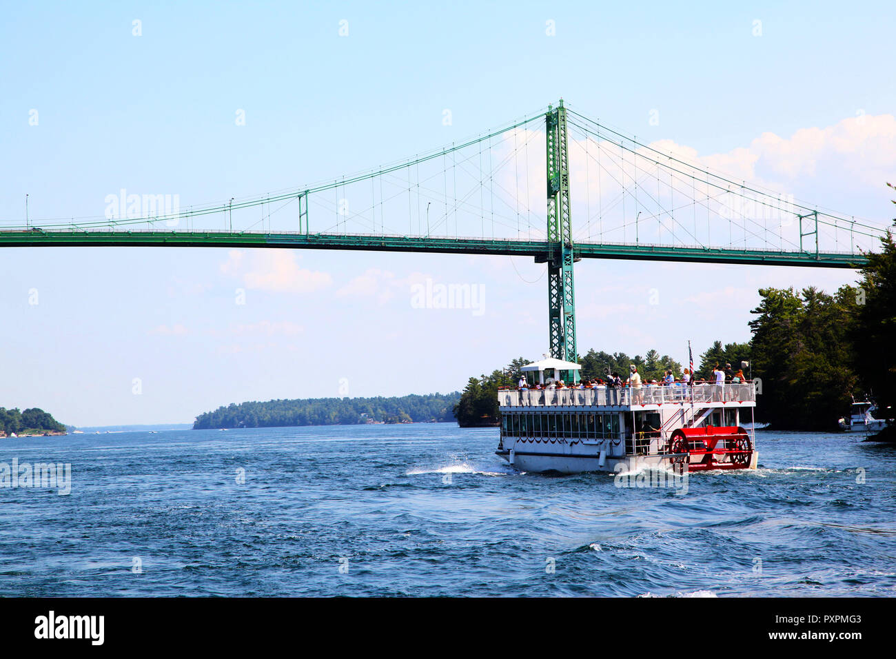 Una crociera barca si avvicina le Mille Isole ponte internazionale sul fiume San Lorenzo il collegamento di New York, Stati Uniti d'America, con l'Ontario, in Canada a metà Foto Stock