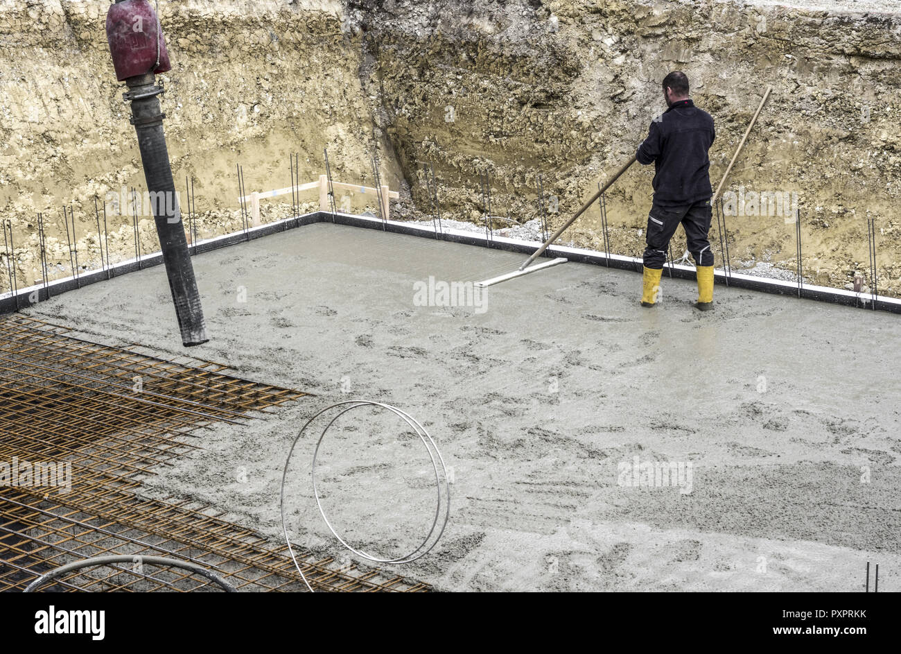 Operaio edile quando cementificazione una fondazione lastra di base costruzione Foto Stock