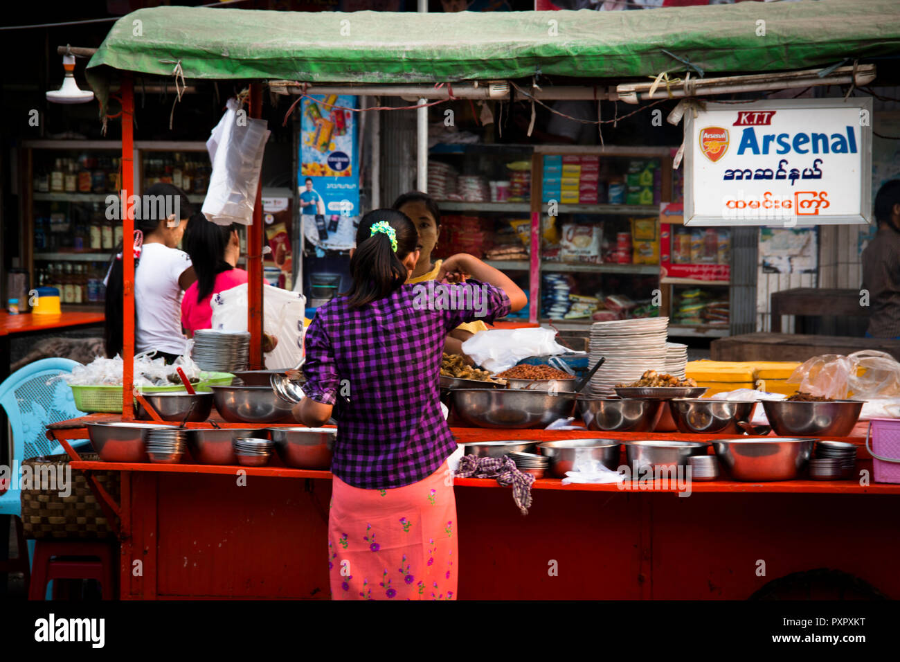 MANDALAY, MYANMAR - Marzo 2018: Donna bying tipico cibo di strada a Mandalay in Myanmar Foto Stock