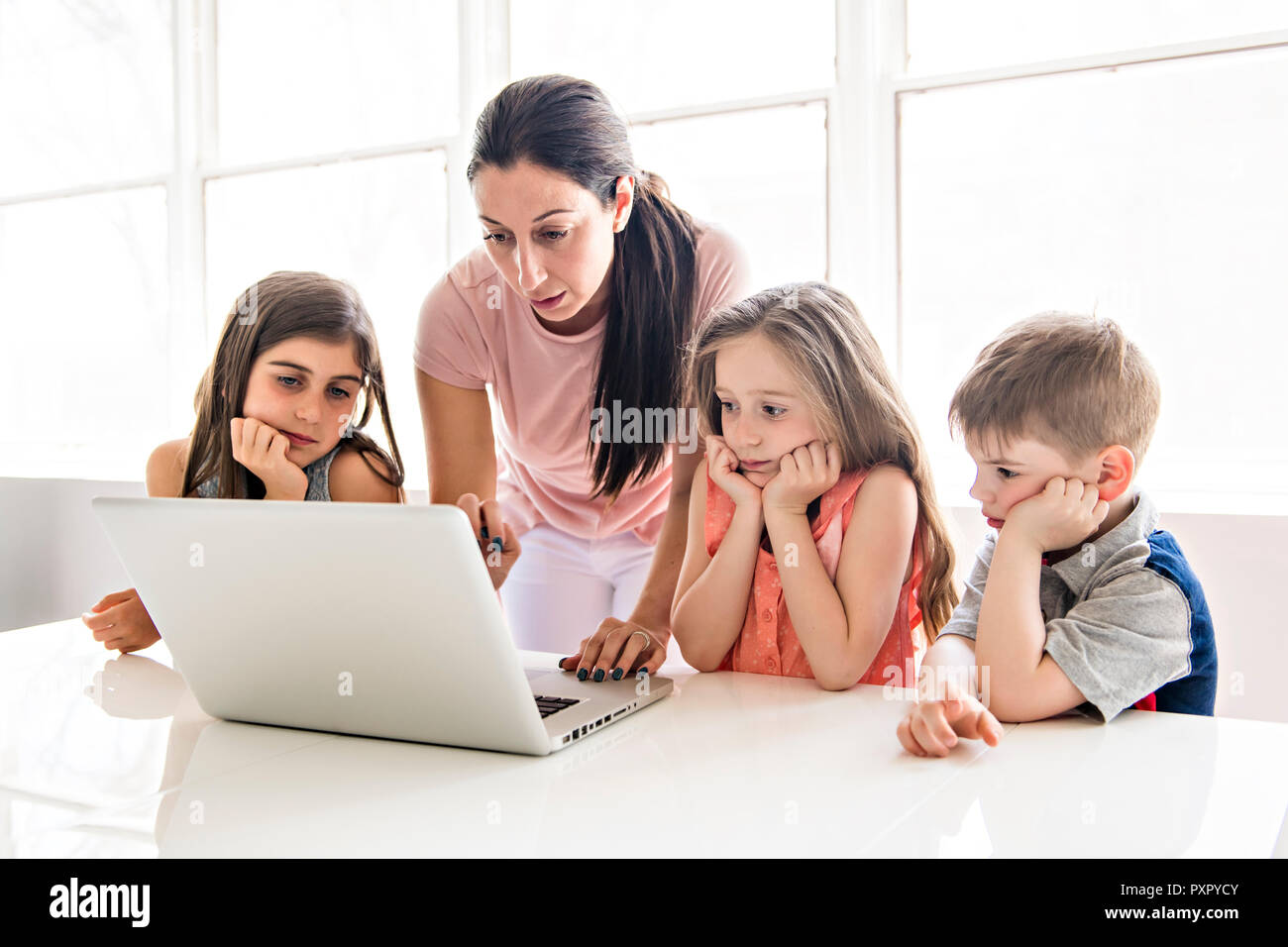 Insegnante con un gruppo di bambini delle scuole con il computer portatile sulla parte anteriore Foto Stock