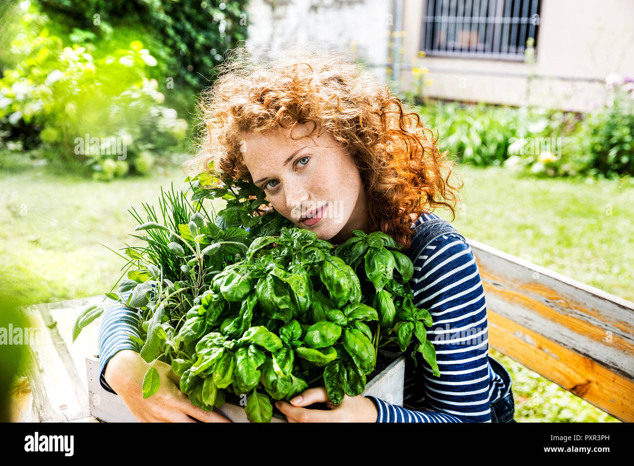 Ritratto di giovane donna con erbe aromatiche fresche in una scatola Foto Stock