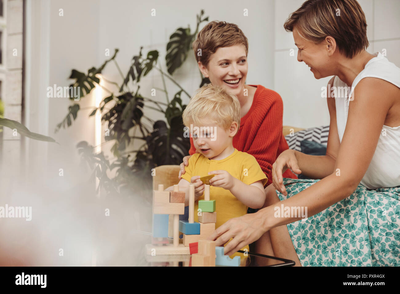 Due madri apprendere e giocare con i loro bambini a casa Foto Stock