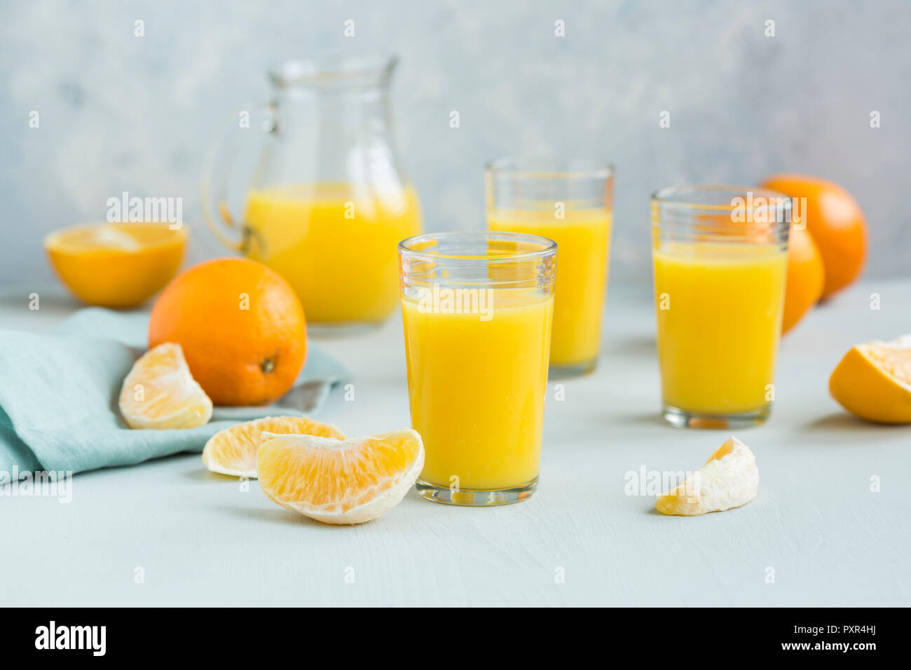 Bicchieri di succo d'arancia appena spremuto e fettine di arancia Foto Stock