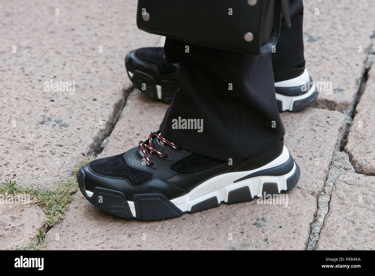 Milano, Italia - 22 settembre 2018: l'uomo con il bianco e nero sneakers prima di Salvatore Ferragamo fashion show, la Settimana della Moda Milanese street style Foto Stock