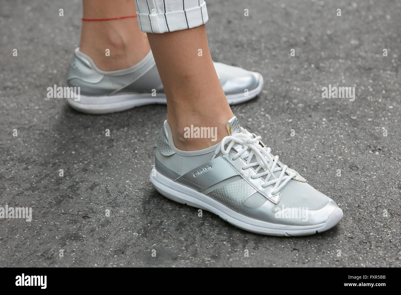 Milano, Italia - 22 settembre 2018: Donna con bianco, grigio e argento Calvin Klein sneakers prima di Salvatore Ferragamo fashion show, la Fashion Week di Milano Foto Stock