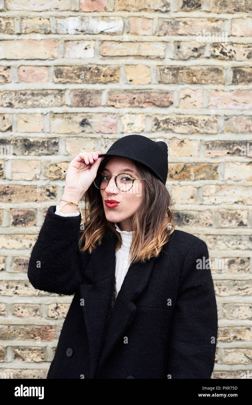 Ritratto di moda donna con labbra rosse che indossa il cappuccio nero e rivestire Foto Stock