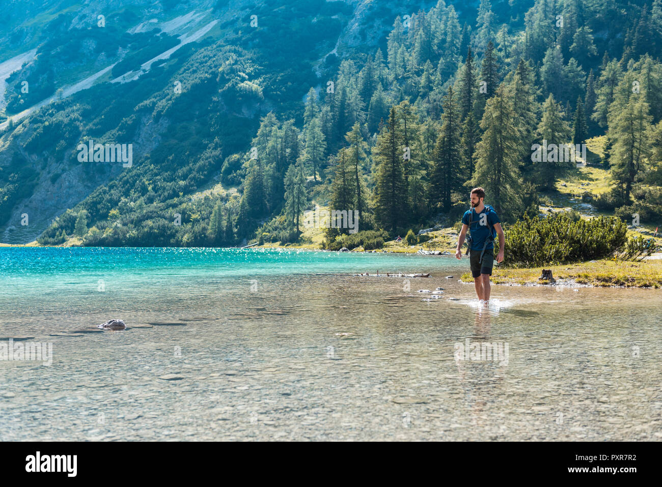 Austria, Tirolo, escursionista presso il lago Seebensee a piedi profondo della caviglia in acqua Foto Stock