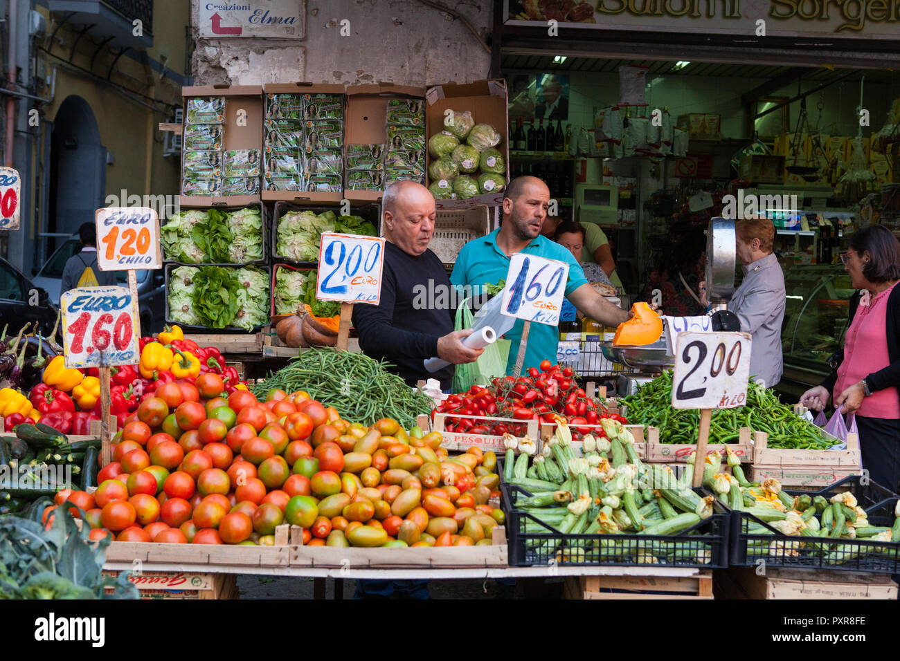 Fruttivendolo del peso di una porzione di zucca al suo di frutta e verdura in stallo il centro storico di Napoli Foto Stock