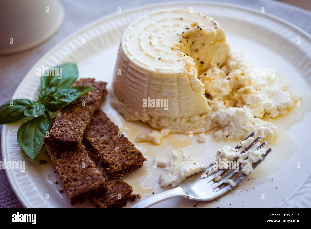 La ricotta con il miele e il pane marrone sulla piastra Foto Stock