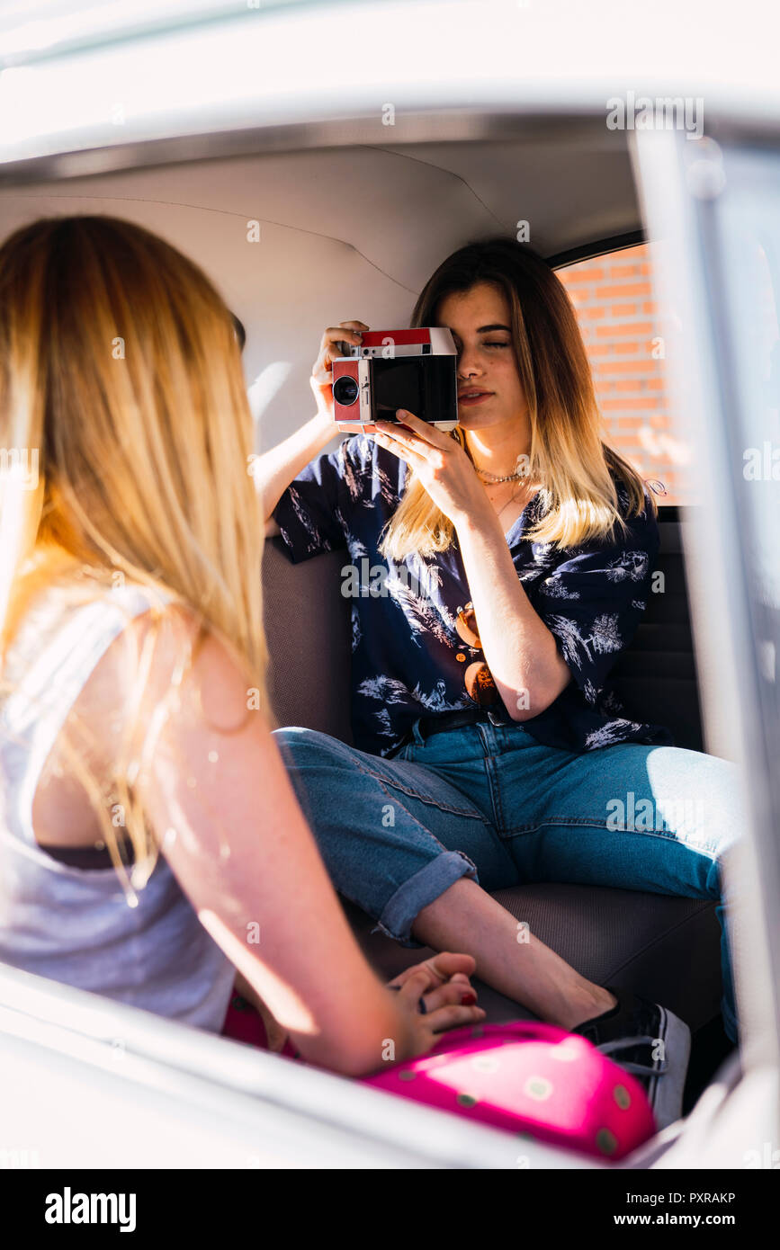 Fotografo di scattare una foto della giovane donna seduta in una macchina Foto Stock
