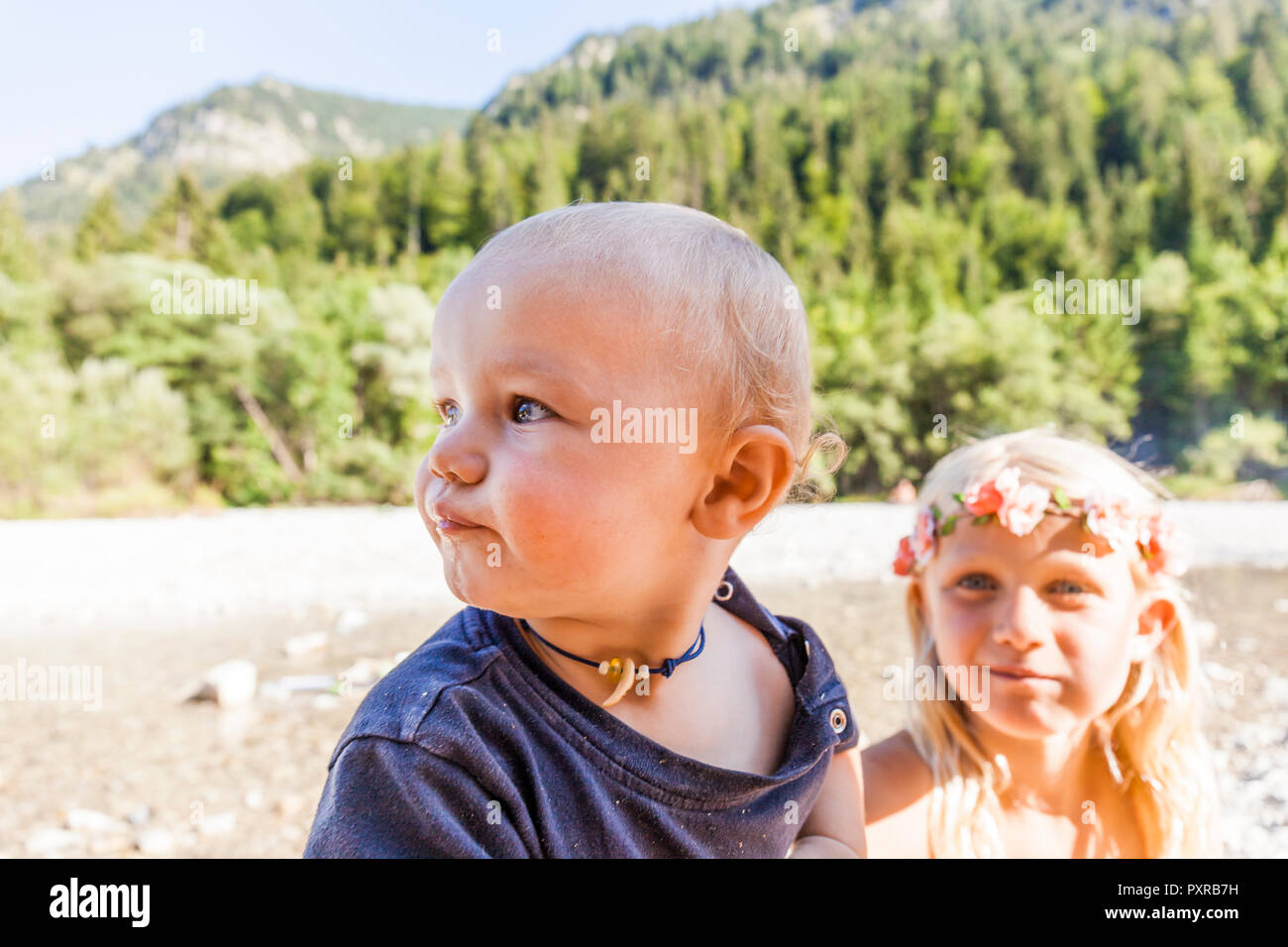 Ritratto di bambino e bambina indossa corona di fiori all'aperto in estate Foto Stock