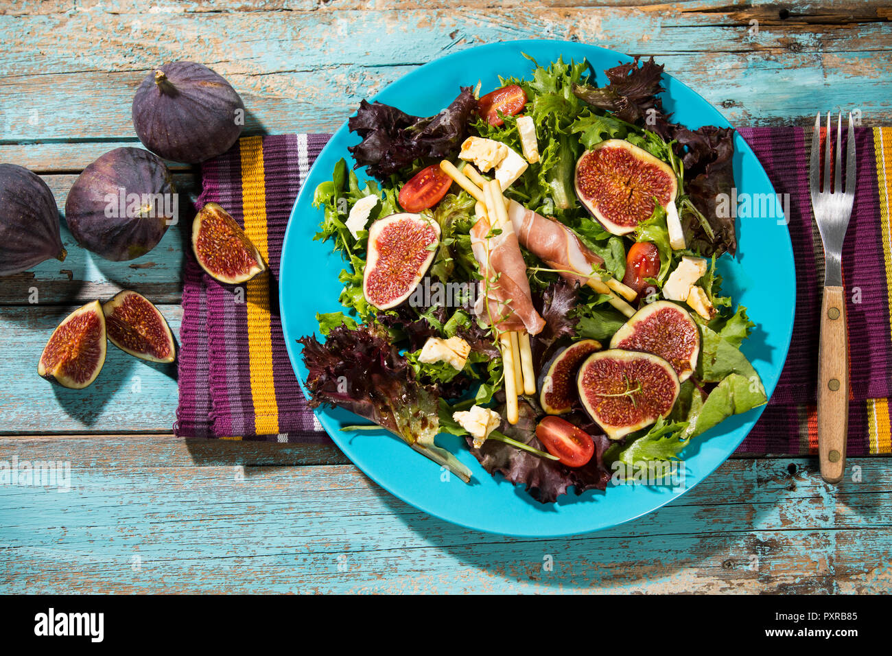 Insalata mista con fichi, pomodori, formaggio di pecora, grissini con prosciutto sulla piastra Foto Stock