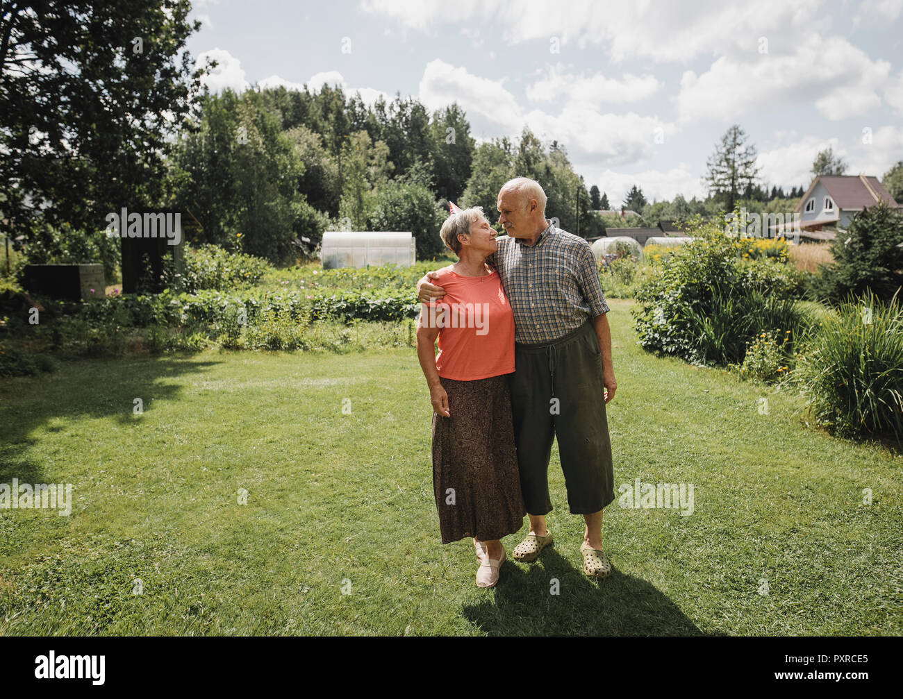 Felice coppia senior in piedi in giardino Foto Stock