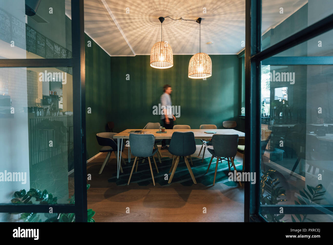 Uomo che cammina da sola in ufficio del suo start up company, orari di lavoro eccessivamente prolungati Foto Stock