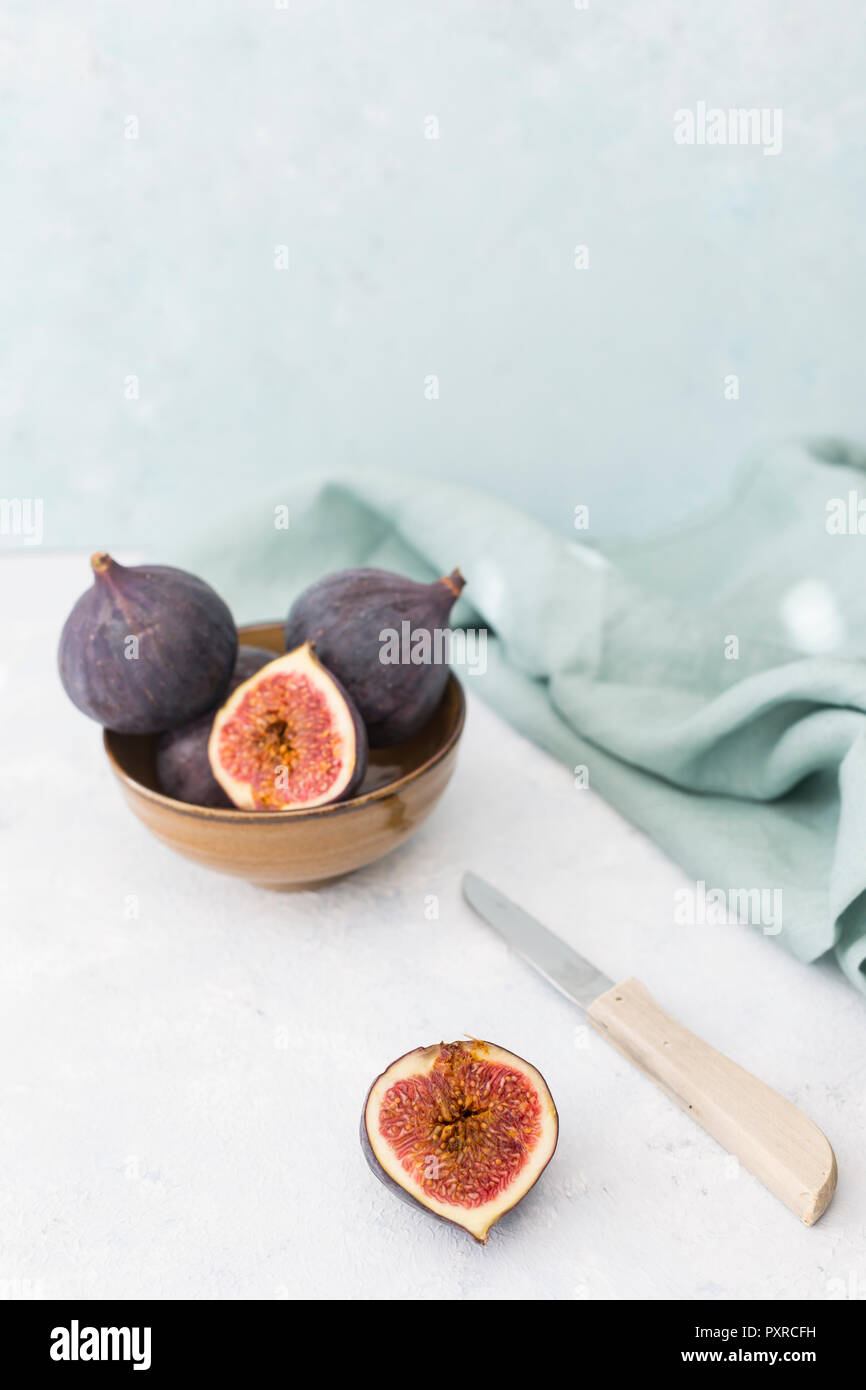 Affettato e intera fichi freschi, coltello da cucina e panno per pulizia Foto Stock