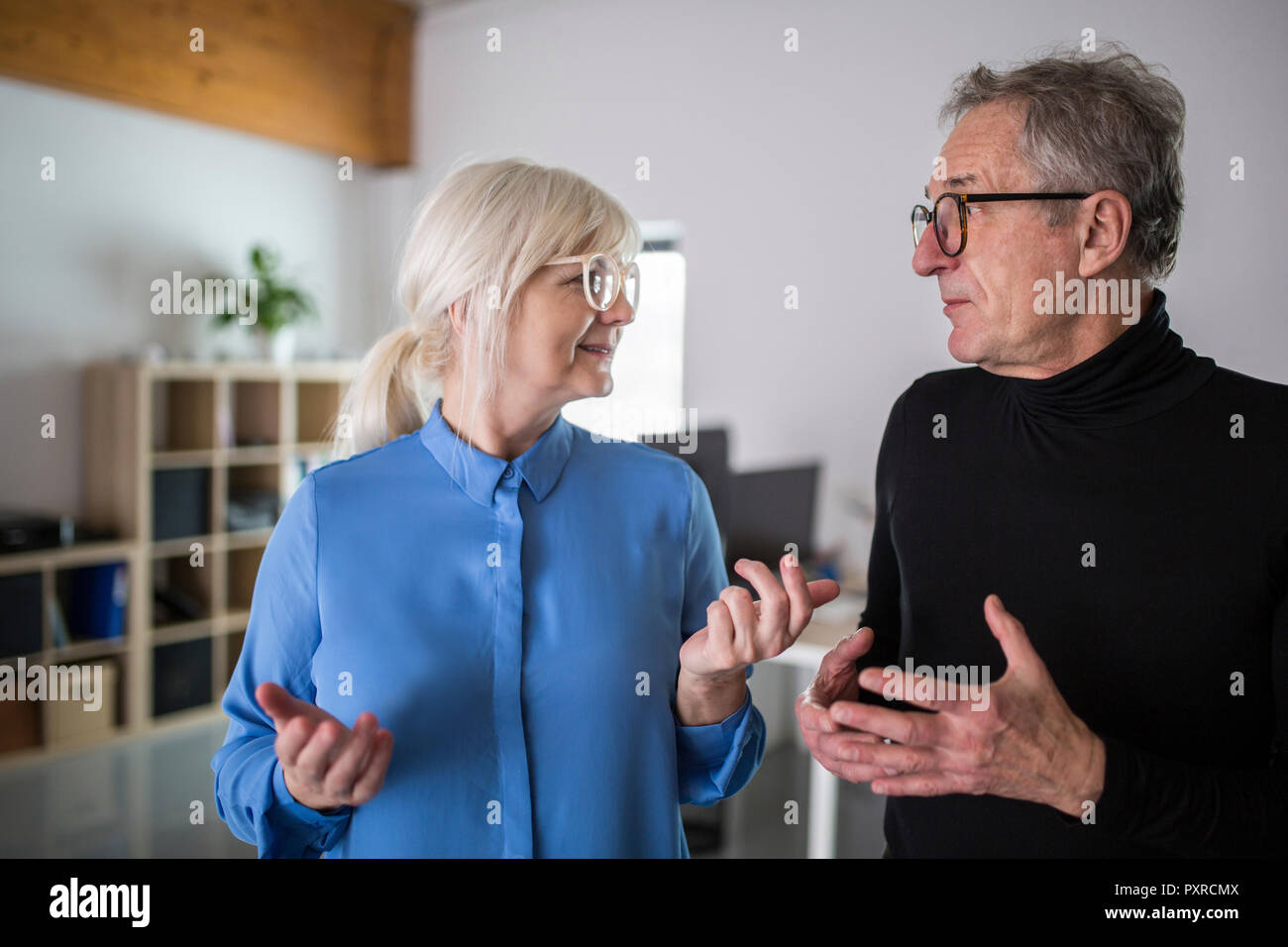 Due colleghi più anziani di discutere in ufficio Foto Stock