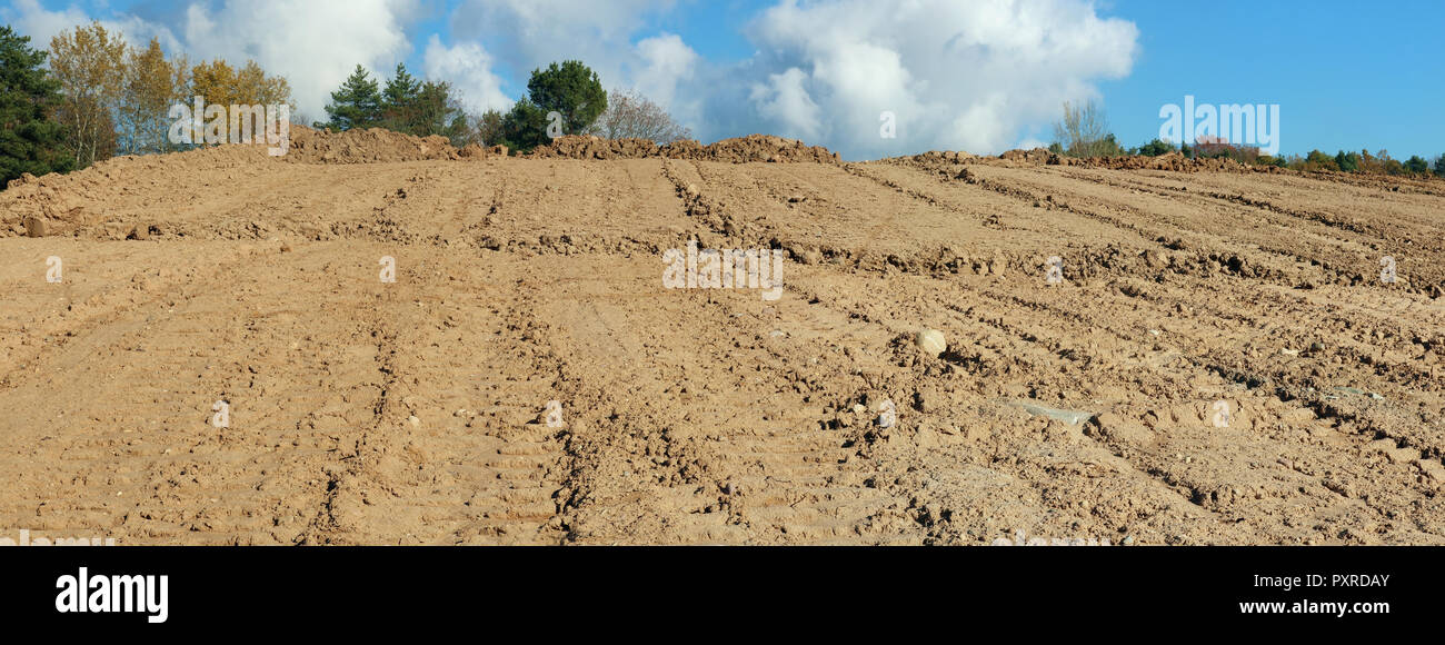 Un gran mucchio di sabbia e tracce di un bulldozer pesanti su una foresta di autunno sito in costruzione. Collage panoramico da diversi outdoor soleggiata giornata di ottobre Foto Stock