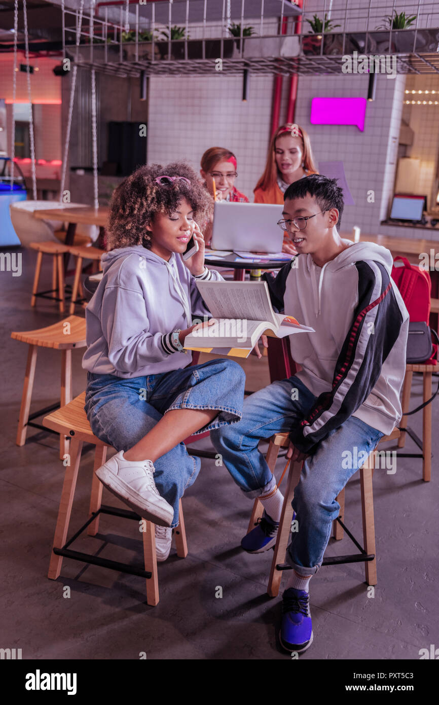 Lieti compagni di classe seduta sul primo piano durante la comunicazione Foto Stock