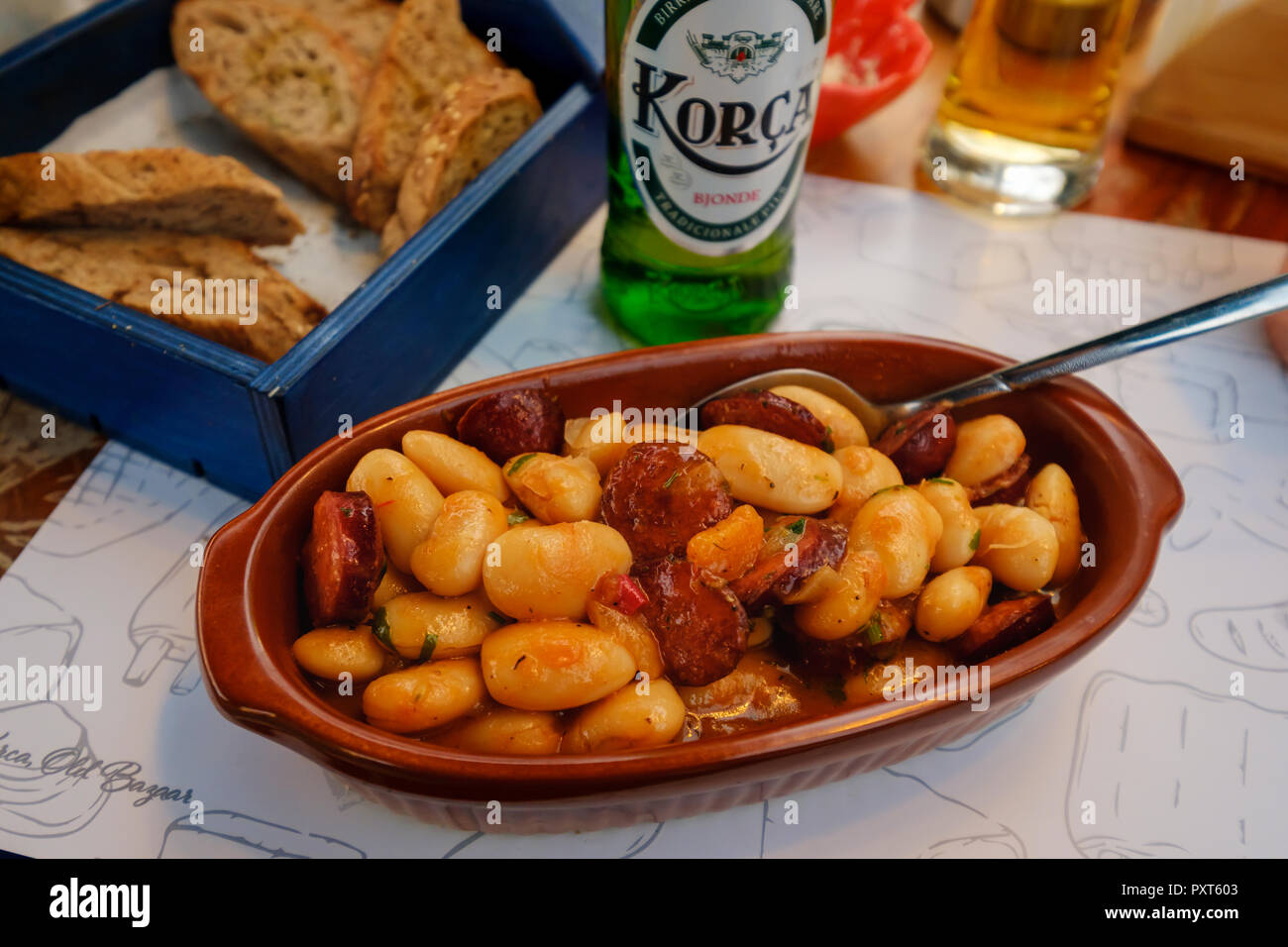 Piatto tipico, stufato di fagioli con salsiccia, Tave e shtëpisë, birra albanese, Korca, Albania Foto Stock