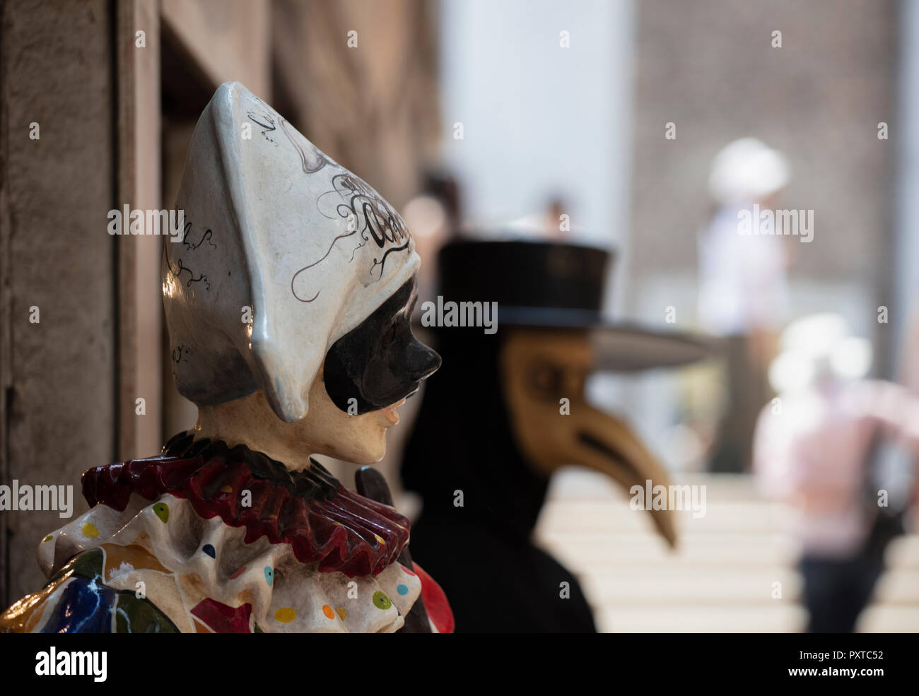 Un modello a grandezza di Harlequin / Arlecchino uno stock di carattere nella Commedia dell'arte al di fuori di un negozio a Venezia. Foto Stock