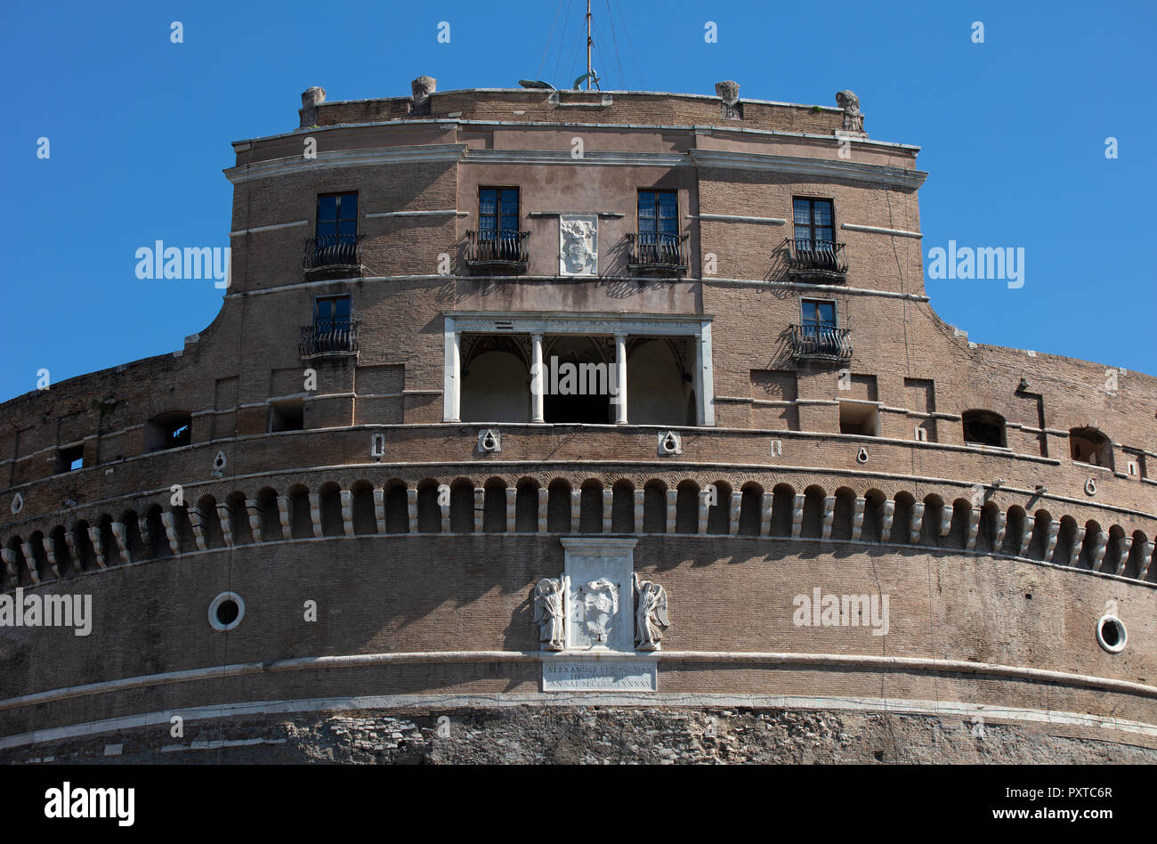 La parte superiore di Castel Sant'Angelo a Roma nella luce del mattino contro un Cielo di estate blu. La stemma papale e la loggia può essere visto. Foto Stock