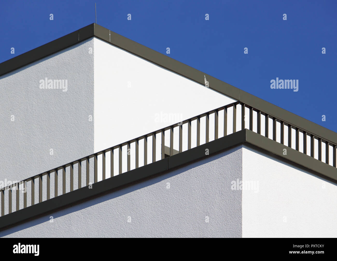 Angolo di un edificio bianco con diagonale di ringhiera di balcone e cielo blu Foto Stock