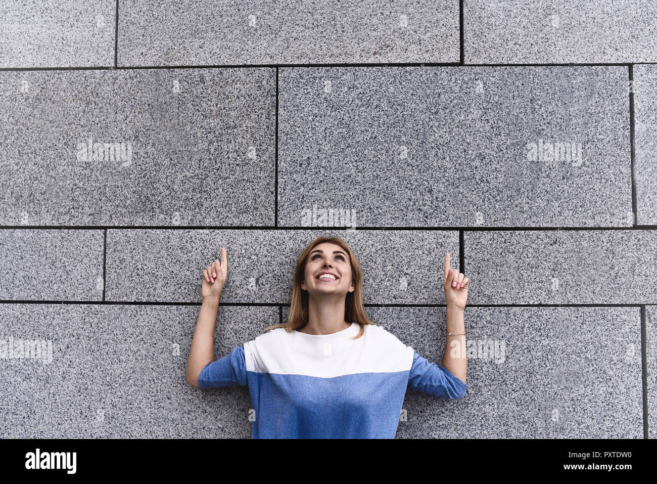 Allegro ragazza alla street, mostrano una grande vendita, o bella offerta. Concetto di pubblicità. Persone, viaggi e turismo - donna su una strada di città e una ragazza mostra con h Foto Stock