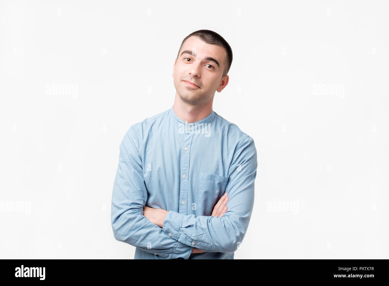 Attraente maschio caucasico rendendo la briga faccia, essendo indifferente e ascolto senza mancanza di interesse Foto Stock