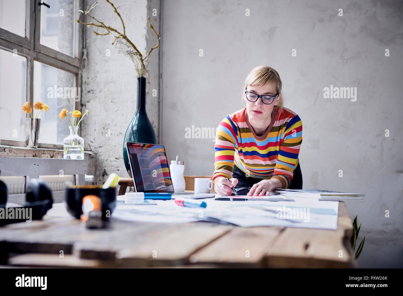 Ritratto di donna che lavorano alla scrivania in un loft Foto Stock