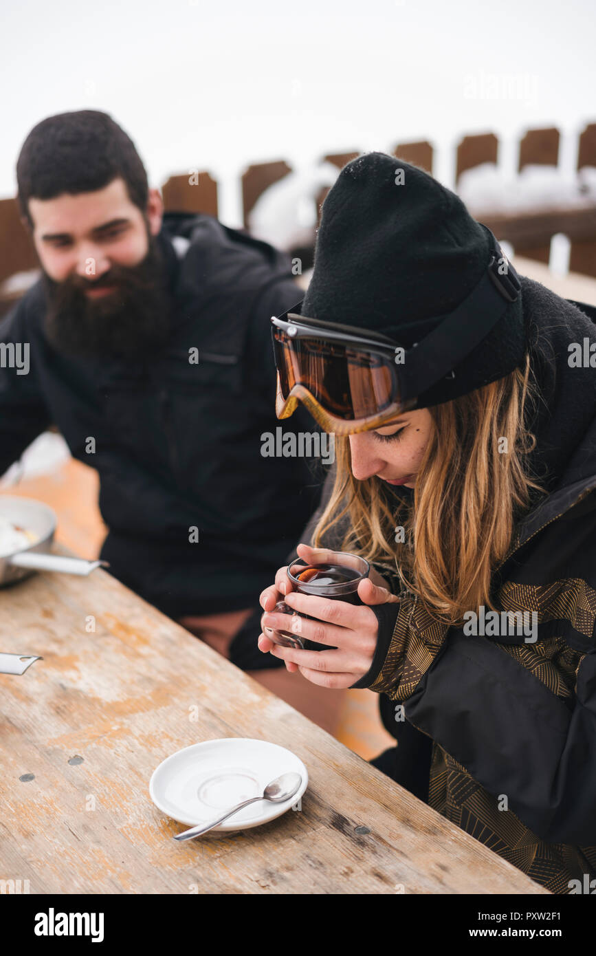 Matura in skiwear avente una bevanda calda al Mountain Lodge Foto Stock