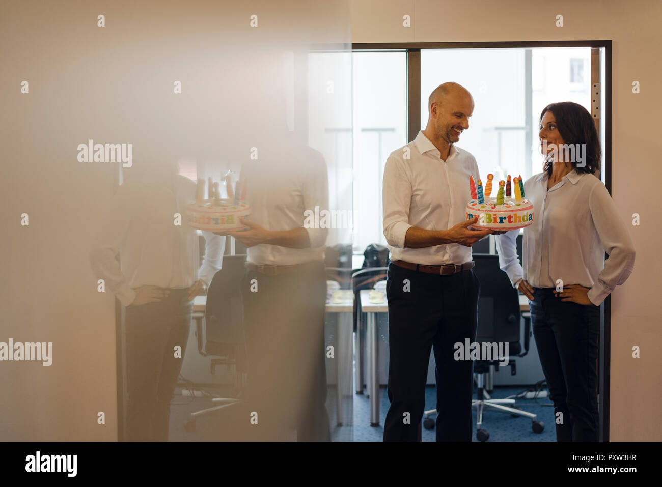 Imprenditore regalare il suo collega con una torta di compleanno in ufficio Foto Stock