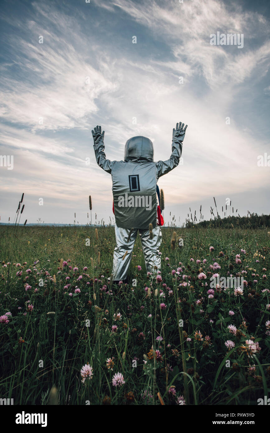 Spaceman esplorando la natura, in piedi nel prato, sventolando Foto Stock