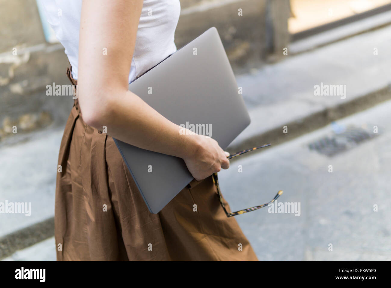 Close-up della donna che la porta laptop all'aperto Foto Stock