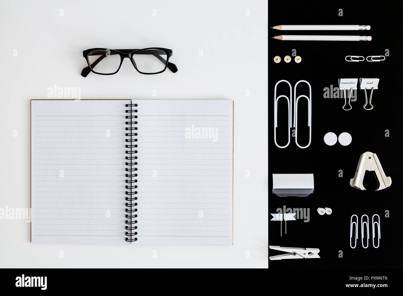 Ufficio bianco utensili su sfondo nero e il blocco note e occhiali su sfondo whilte Foto Stock
