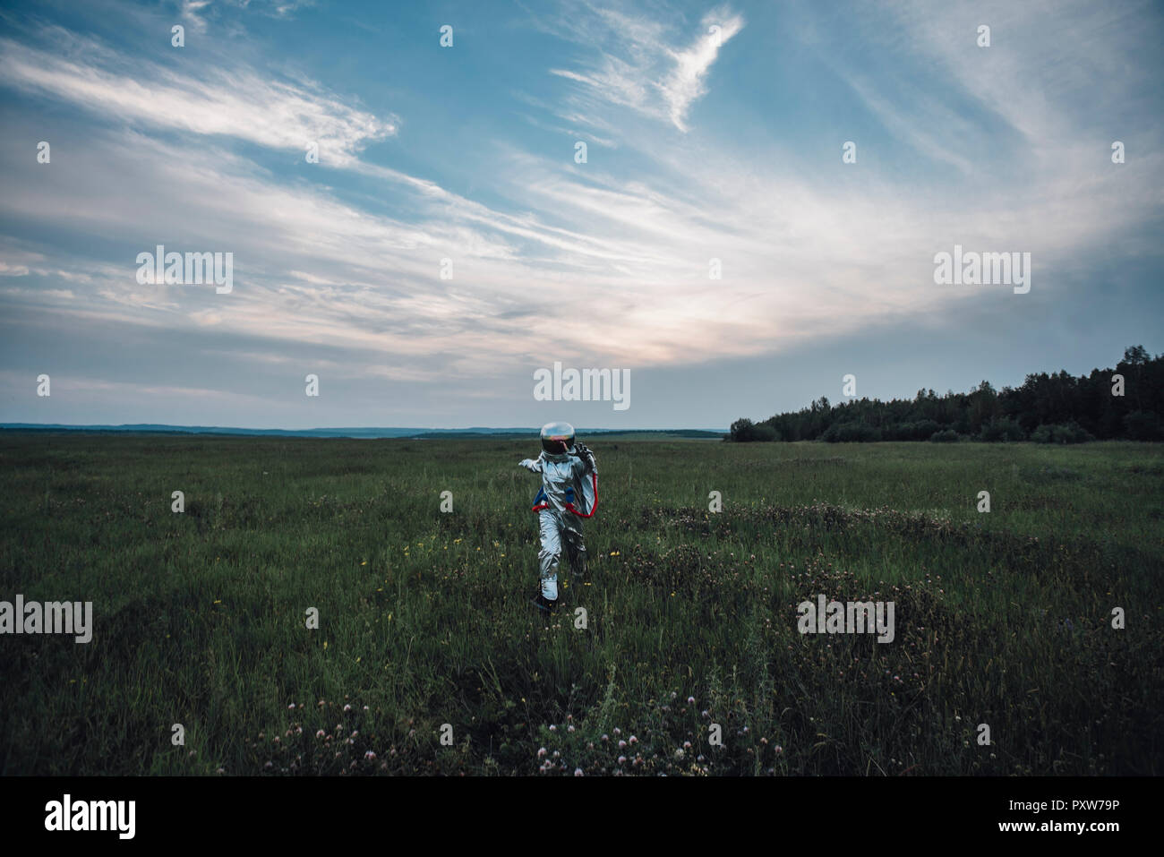 Spaceman esplorando la natura, passeggiate in Prato Foto Stock