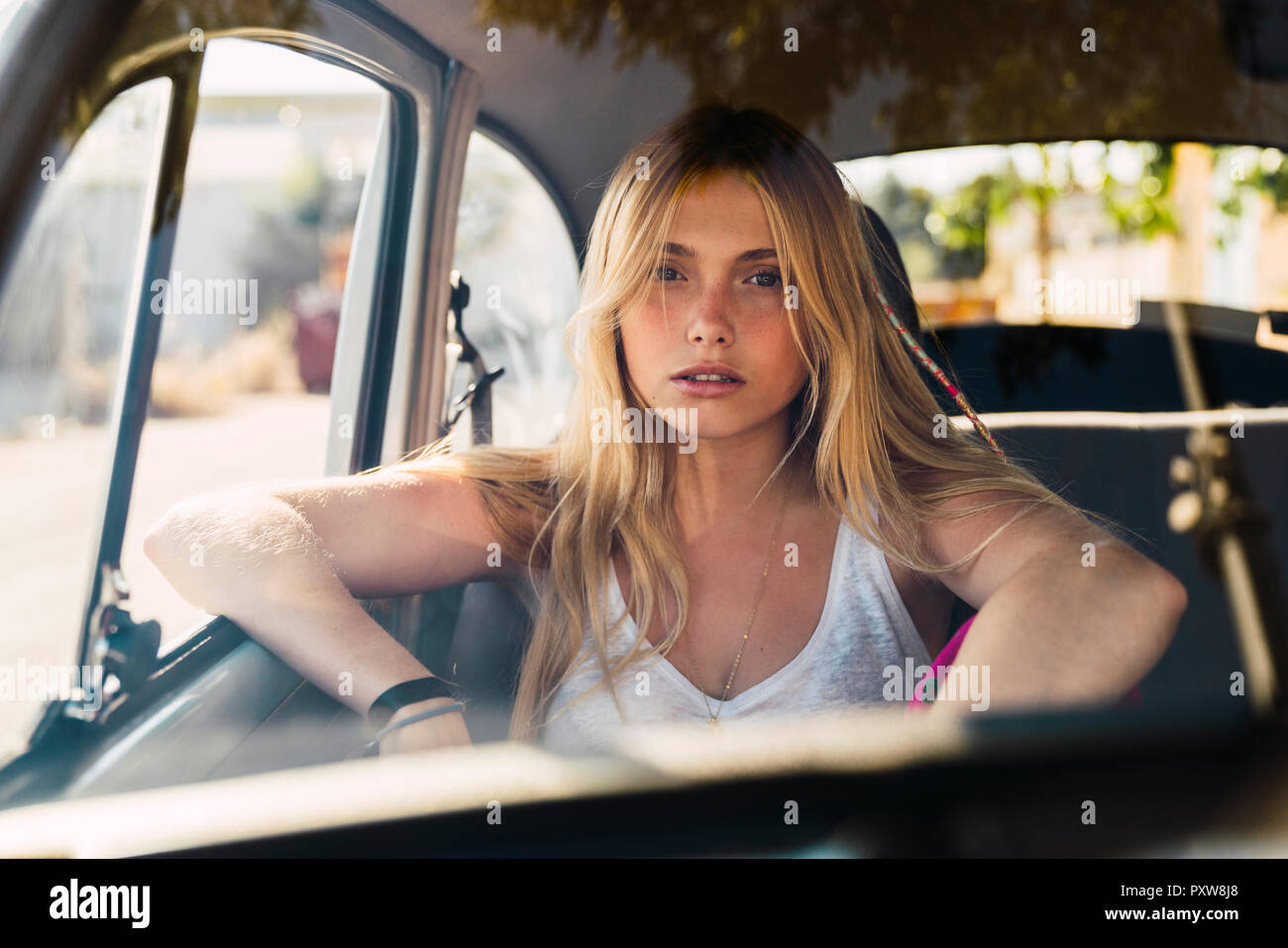 Ritratto di giovane donna seduta in una macchina Foto Stock