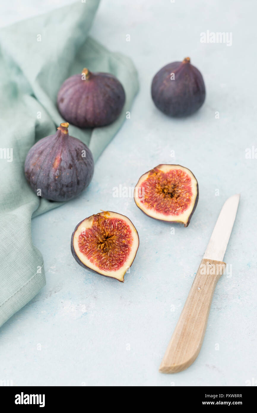 Affettato e intera fichi freschi, coltello da cucina e panno per pulizia Foto Stock