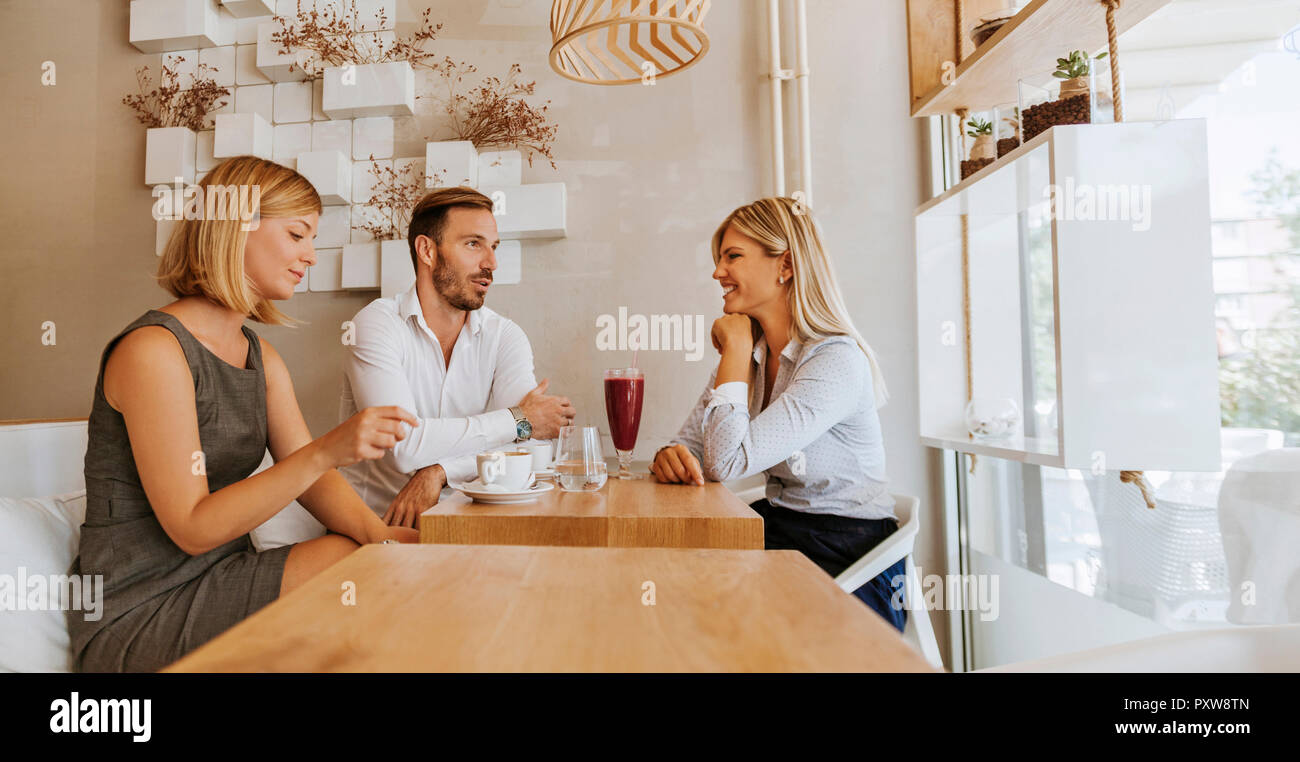 Tre amici riuniti in un cafe Foto Stock