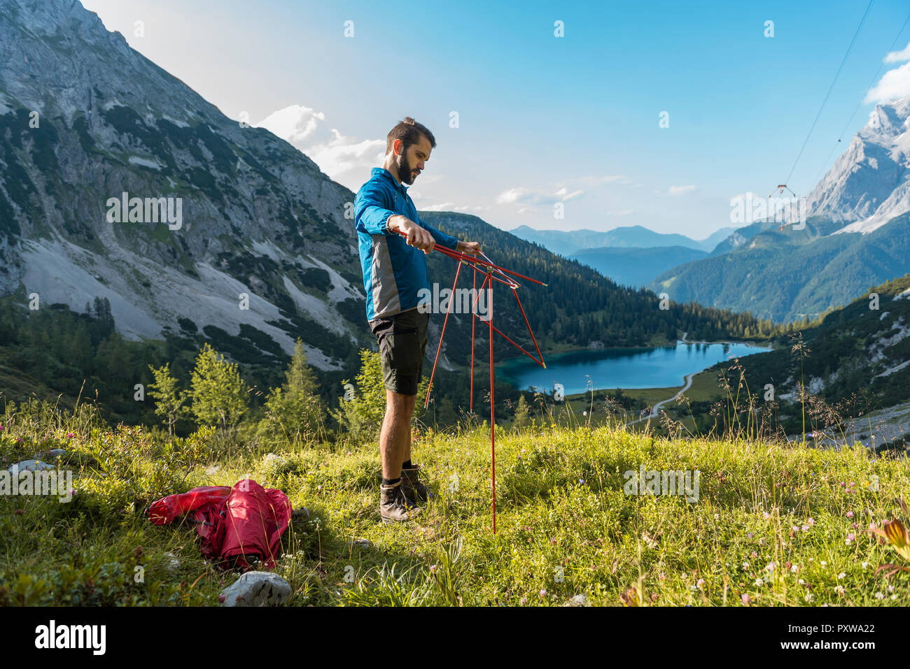 Austria, Tirolo, Escursionista impostando la sua tenda in montagna al lago Seebensee Foto Stock