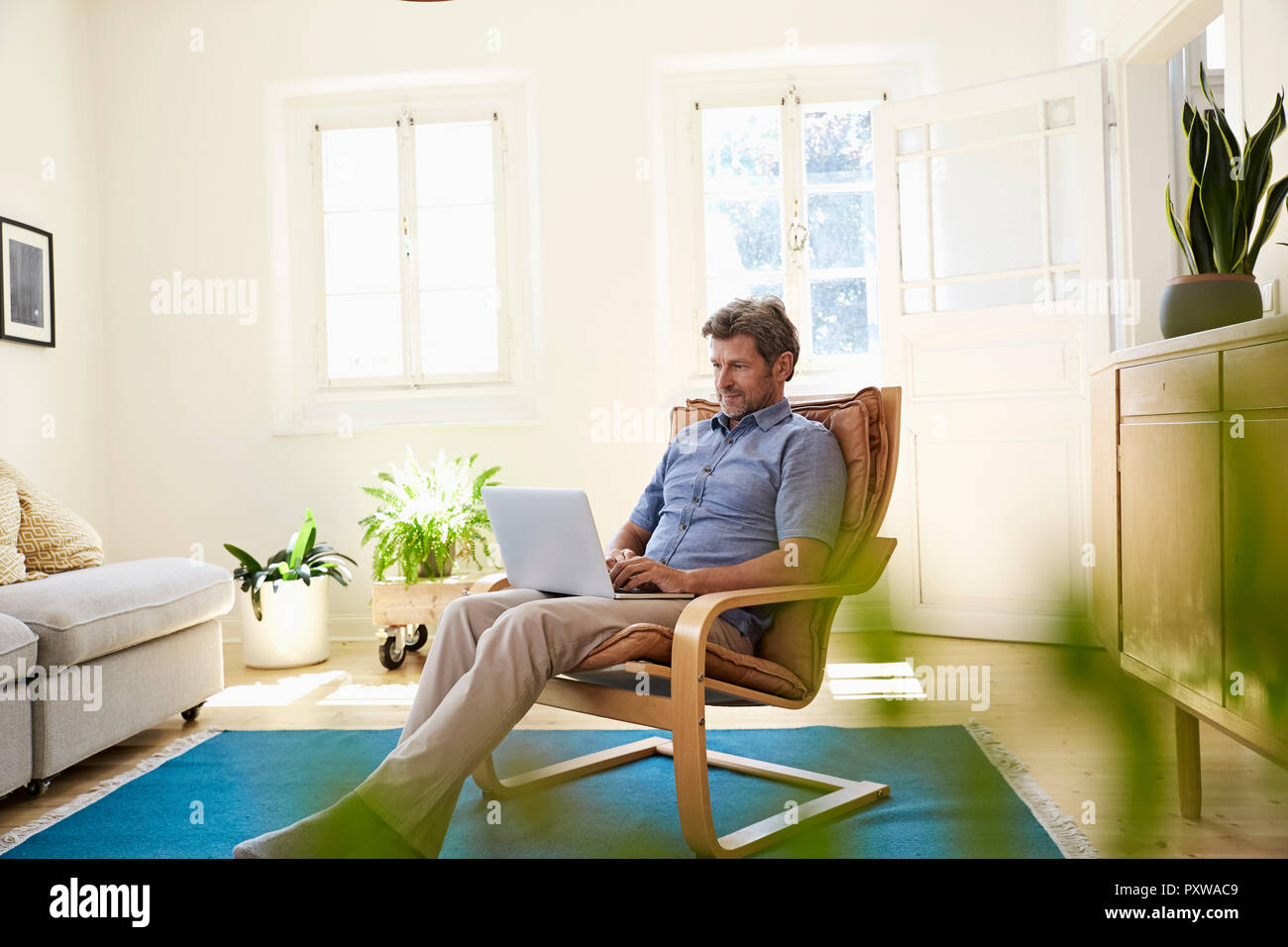 Uomo che lavora a casa utilizzando laptop Foto Stock