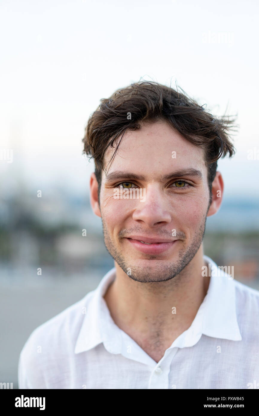 Ritratto di sorridente giovane con capelli tousled all'aperto Foto Stock