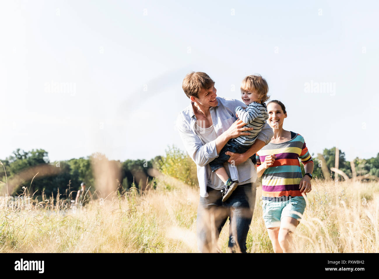 La famiglia felice passeggiate in riva al fiume e su un bel giorno di estate Foto Stock