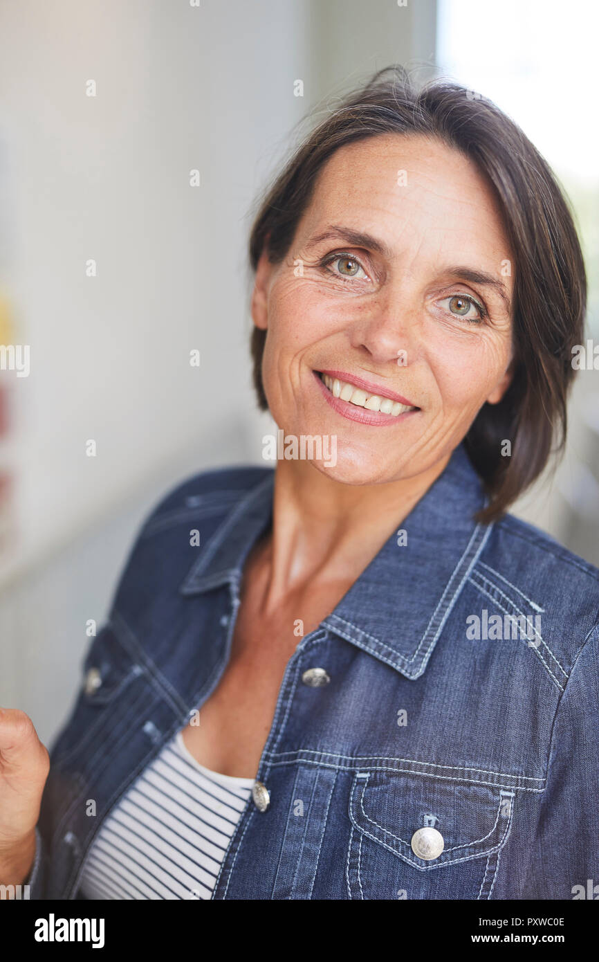 Ritratto di sorridere donna matura indossando il denim shirt Foto Stock