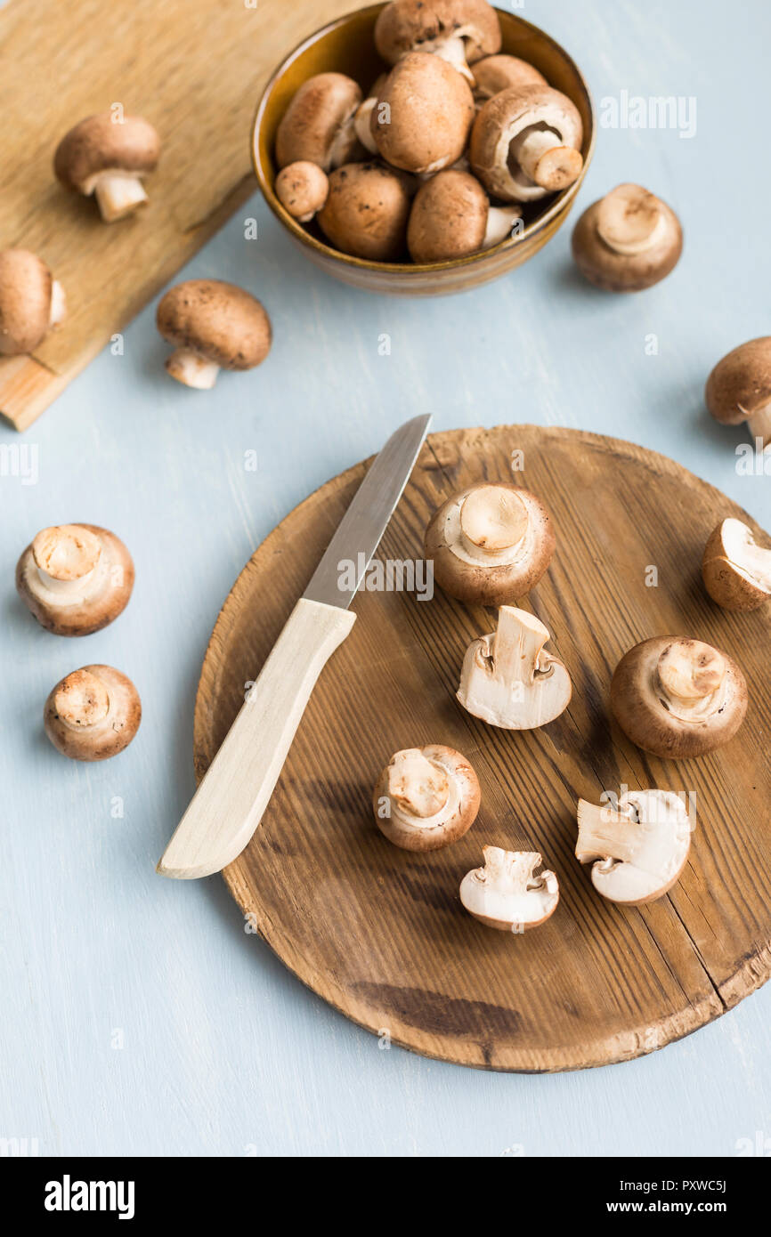 Affettato e intera Crimini funghi sulla tavola di legno Foto Stock