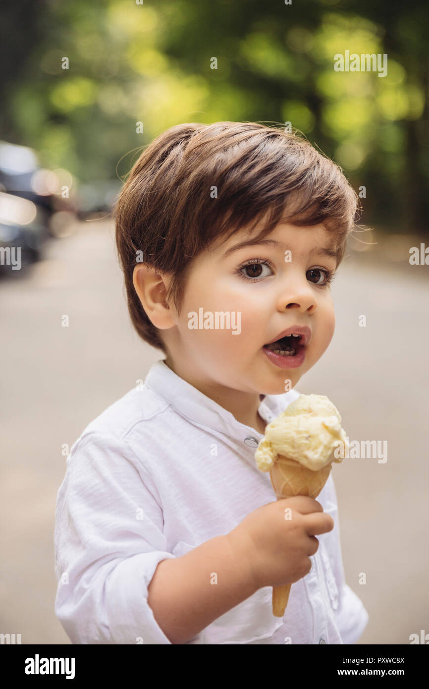 Ritratto di bambino con gelato alla vaniglia il cono in posizione di parcheggio Foto Stock