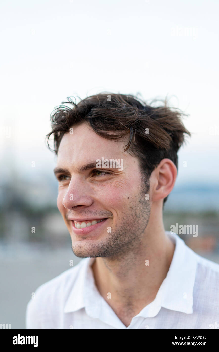 Ritratto di sorridente giovane con capelli tousled all'aperto Foto Stock