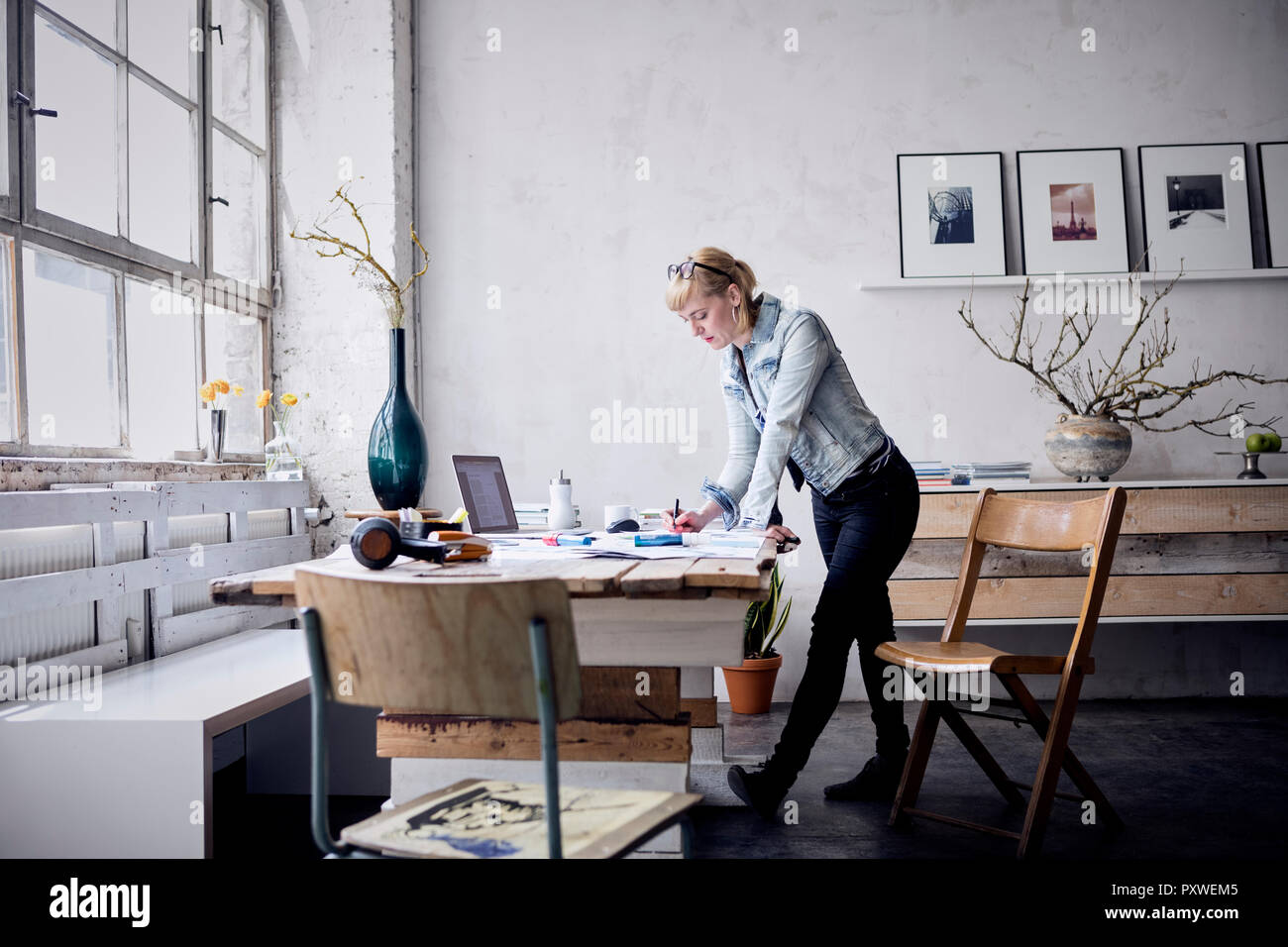 Donna che lavorano alla scrivania in un loft Foto Stock