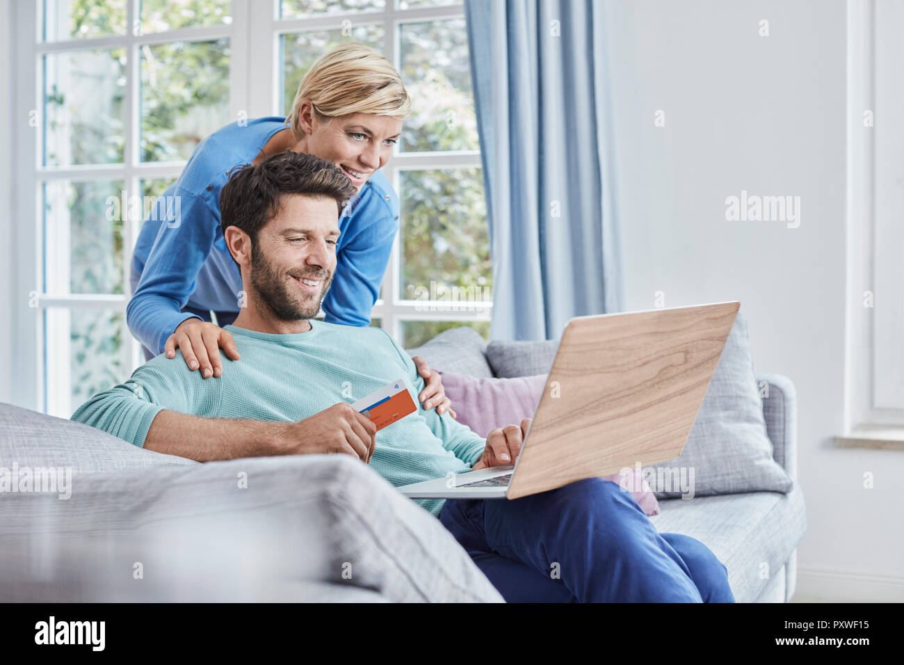 Coppia felice a casa lo shopping online Foto Stock