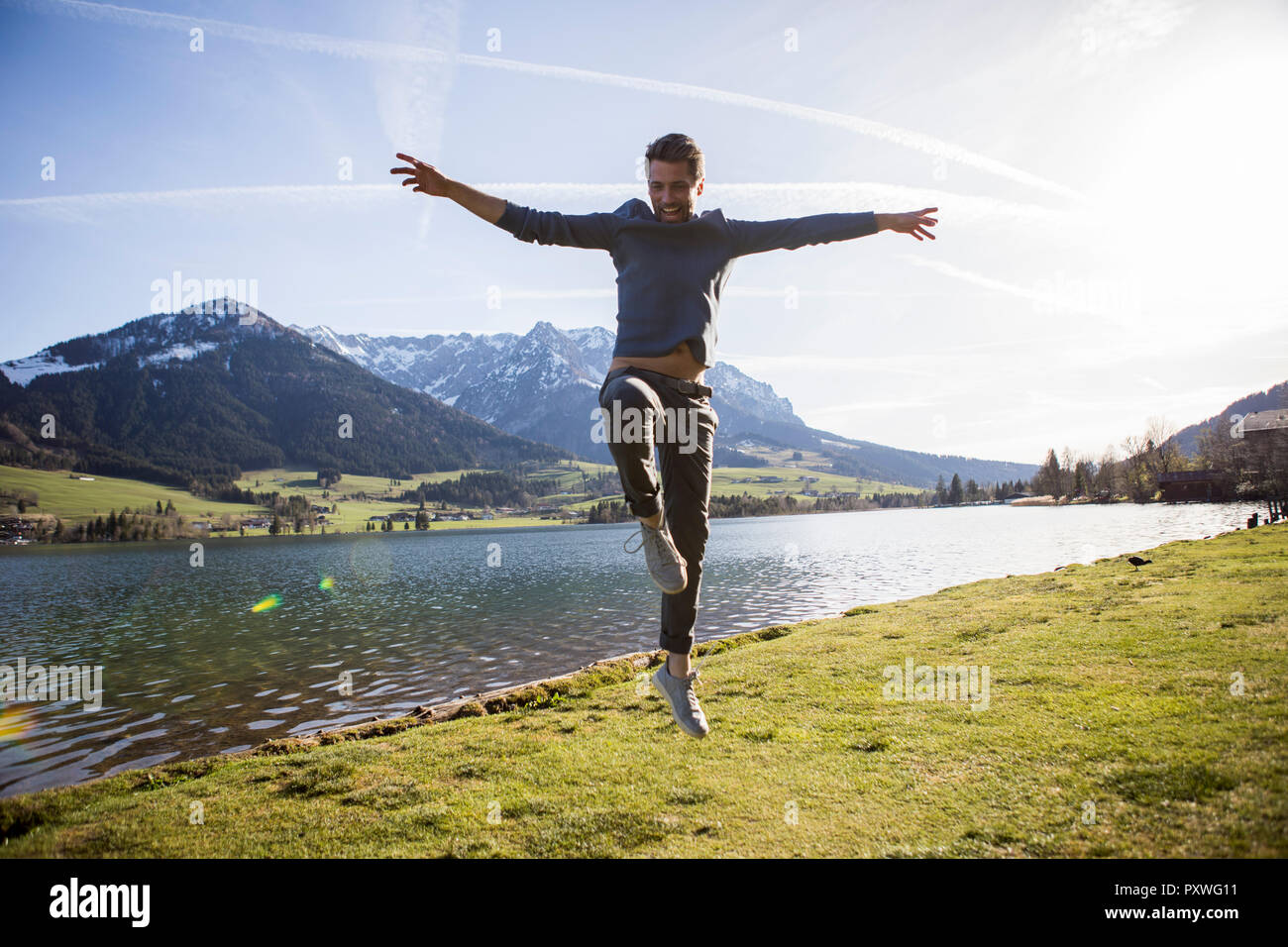 Austria, Tirolo, Walchsee, uomo felice saltando al lago Foto Stock